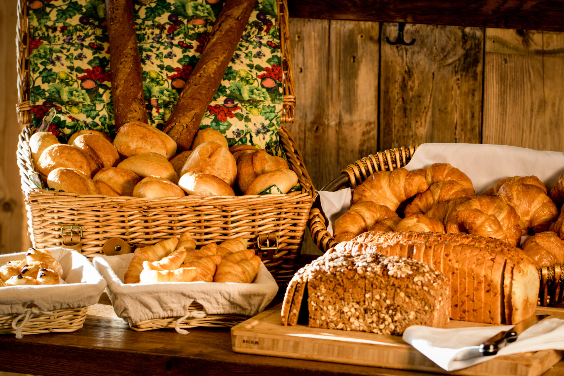 Brotkörbe mit Brötchen, Croissants und geschnittenem Brot beim Frühstücksbuffet