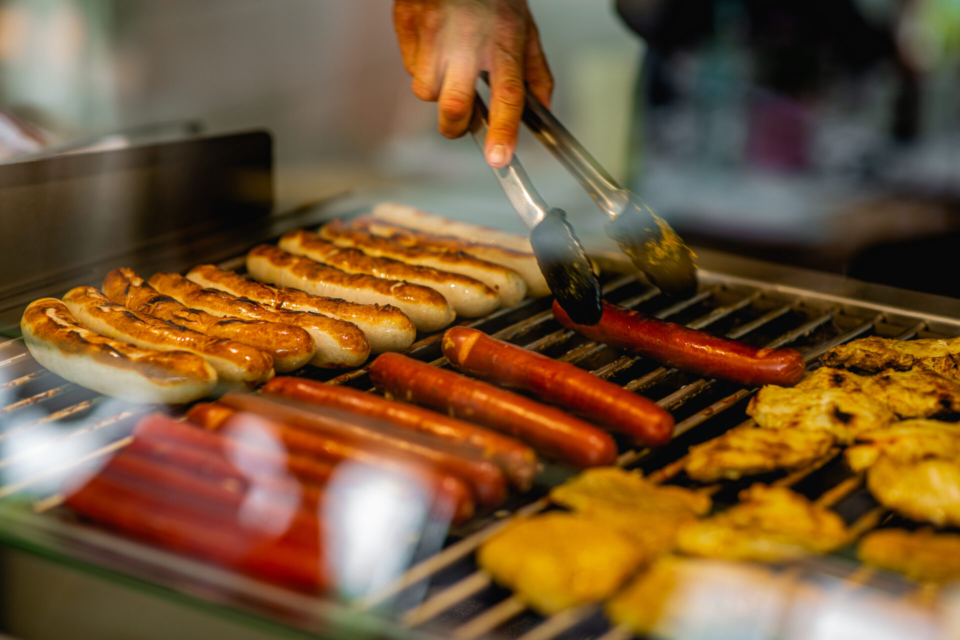Nahaufnahme eines Grillrosts mit Bratwürstchen drauf