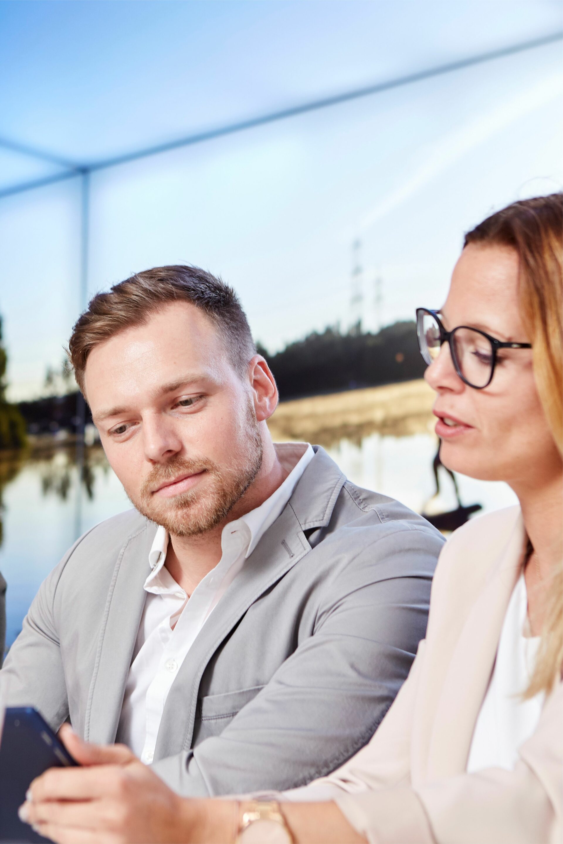 seehaus-langenfeld-tagungsraum-meeting Frau zeigt ihrem Kollegen Inhalte auf dem Tablet. Im Hintergrund ist der Tagungsraum zu sehen.